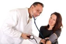 Doctor taking blood pressure of woman patient