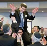 Chosson (groom) lifted onto a chair while men dance around him
