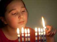 Young girl lighting Chanukah candles