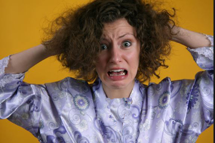 A woman frustrated by her frizzy hair