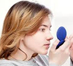 A woman searching her face to see if she has blackheads